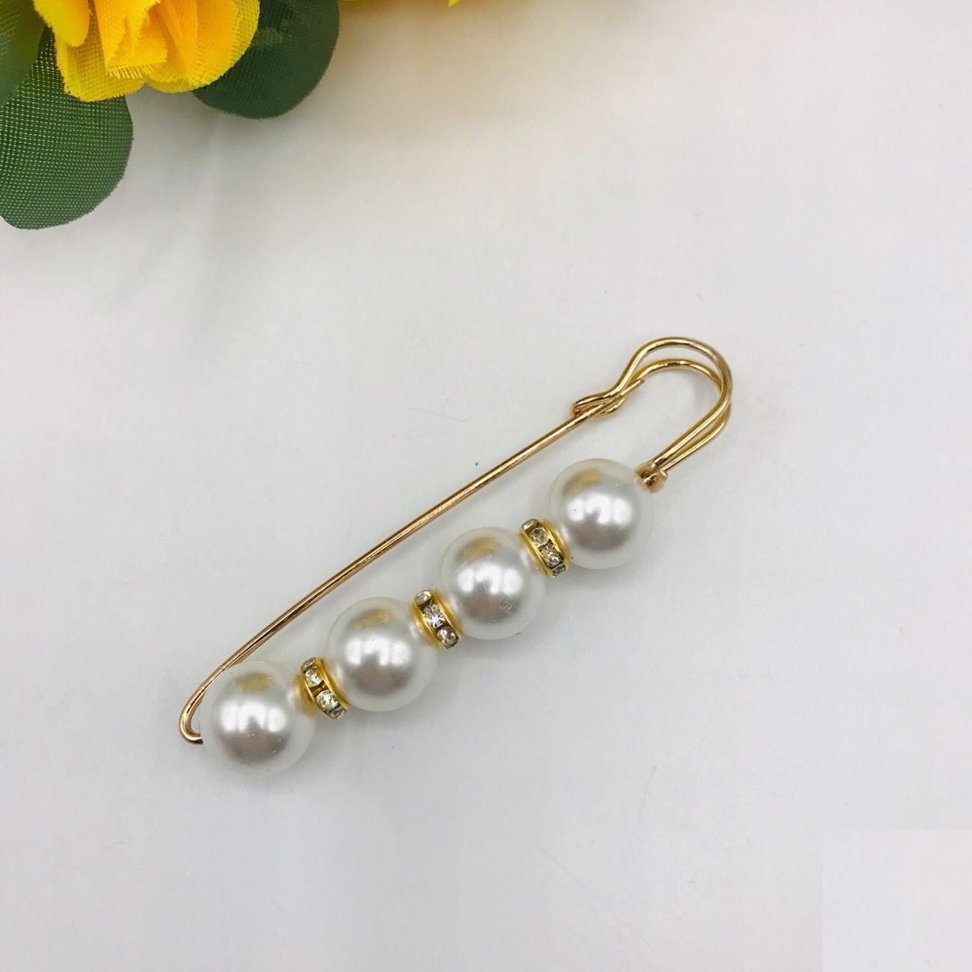 золотая булавка на девушке. женская булавка. булавка с бронзовым пистолетом. брошь булавка золото. женская булавка.